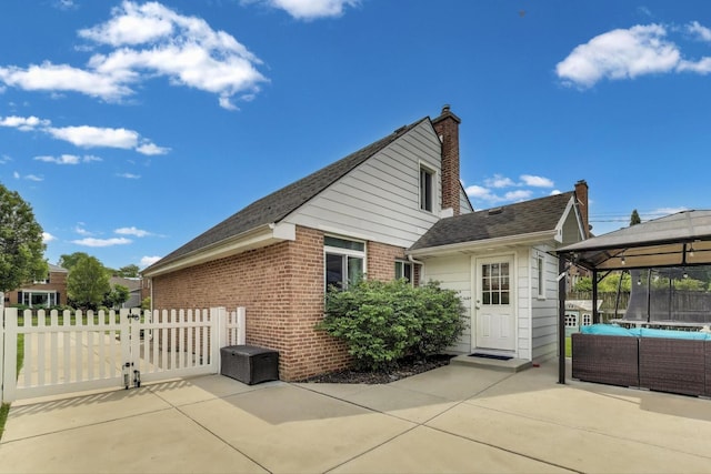 614 Beach Ave, La Grange Park, IL 60526 - view of property exterior featuring a trampoline, a patio, brick siding, a gate, and a gazebo