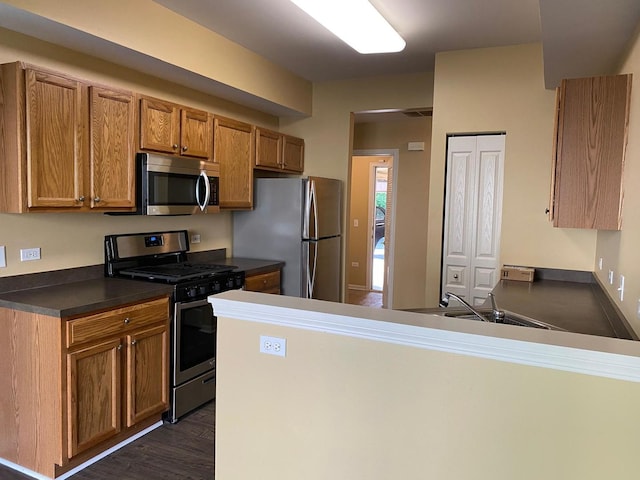 3148 Ollerton Ave Unit 3148, Aurora, IL 60502 - kitchen with stainless steel appliances, dark countertops, a peninsula, dark wood-style flooring, and brown cabinetry
