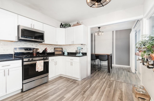 352 Falcon Ridge Way, Bolingbrook, IL 60440 - kitchen with appliances with stainless steel finishes, backsplash, light wood-type flooring, and dark countertops