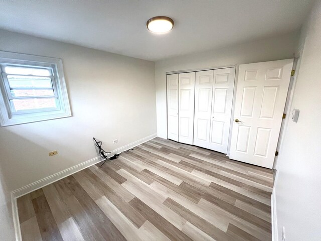 6842 W Lode Dr Unit 3B, Worth, IL 60482 - unfurnished bedroom with light wood finished floors, baseboards, and a closet