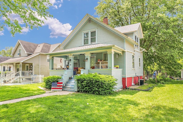 138 N Elm St, Paxton, IL 60957 - view of front of property with a porch, a chimney, a front lawn, and central AC