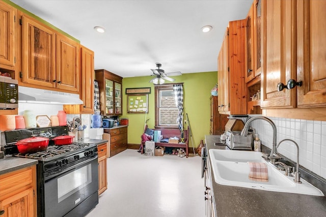 138 N Elm St, Paxton, IL 60957 - kitchen featuring a sink, black range with gas stovetop, under cabinet range hood, tasteful backsplash, and dark countertops