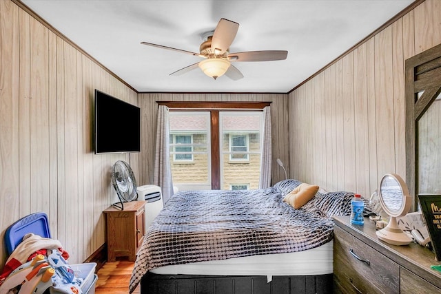 138 N Elm St, Paxton, IL 60957 - bedroom with ornamental molding, light wood-style floors, wooden walls, and a ceiling fan