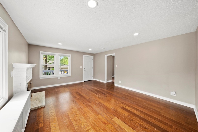 23951 N Lakeside Dr, Lake Zurich, IL 60047 - unfurnished living room with wood finished floors, recessed lighting, a textured ceiling, and a fireplace