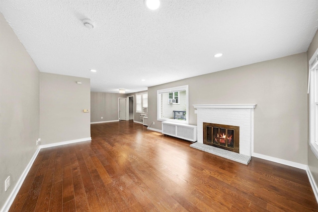 23951 N Lakeside Dr, Lake Zurich, IL 60047 - unfurnished living room featuring radiator, wood finished floors, a fireplace, recessed lighting, and a textured ceiling