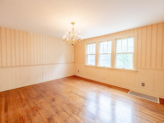 4513 Schwartz Ave, Lisle, IL 60532 - empty room with a chandelier, wood finished floors, and wallpapered walls