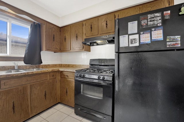 5739 W 63rd St Unit 3S, Chicago, IL 60638 - kitchen with black appliances, under cabinet range hood, brown cabinets, light tile patterned floors, and decorative backsplash