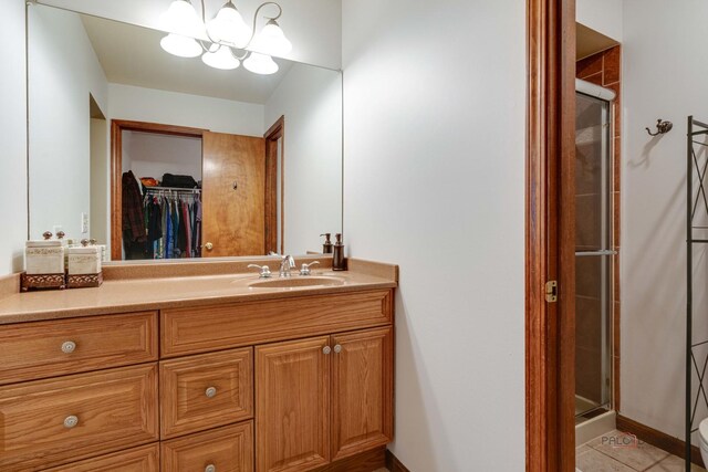 325 Pearl St, Cary, IL 60013 - bathroom featuring a shower stall, vanity, a walk in closet, and tile patterned floors