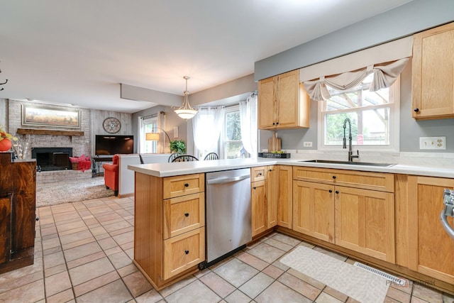 325 Pearl St, Cary, IL 60013 - kitchen with stainless steel dishwasher, a sink, a peninsula, a fireplace, and light countertops