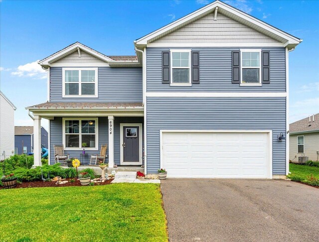 6904 Spruce Ct, Wonder Lake, IL 60097 - view of front of home with a porch, asphalt driveway, a front lawn, and a garage