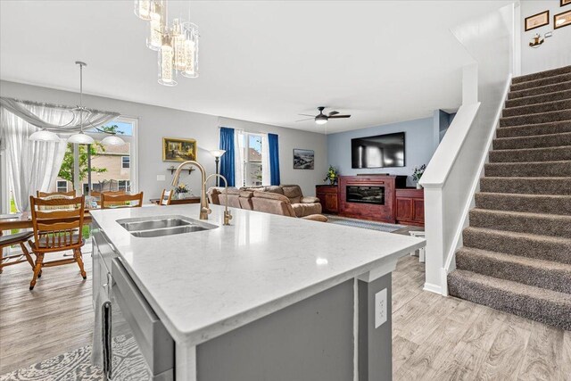 6904 Spruce Ct, Wonder Lake, IL 60097 - kitchen with a sink, dishwasher, light wood-type flooring, ceiling fan, and a fireplace
