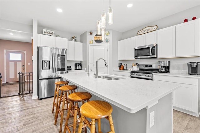 6904 Spruce Ct, Wonder Lake, IL 60097 - kitchen featuring stainless steel appliances, a sink, a breakfast bar area, light countertops, and a center island with sink