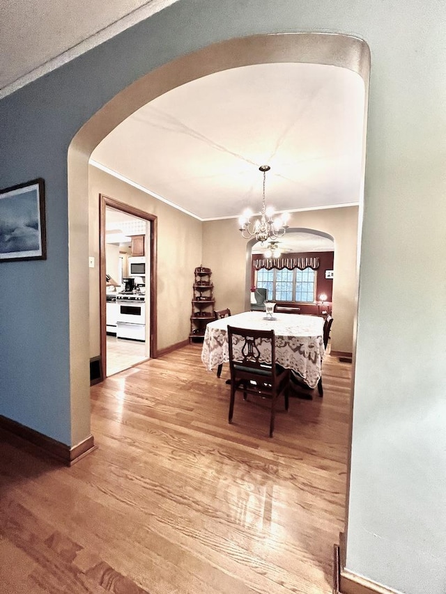 9214 S Sacramento Ave, Evergreen Park, IL 60805 - dining space featuring arched walkways, wood finished floors, a chandelier, ornamental molding, and baseboards