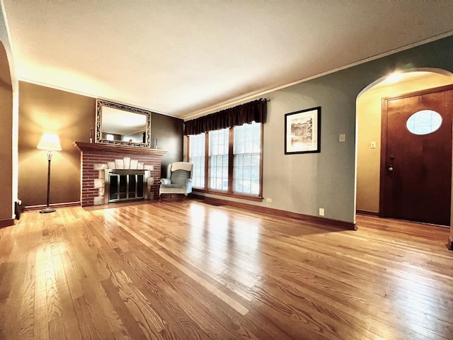 9214 S Sacramento Ave, Evergreen Park, IL 60805 - unfurnished living room with arched walkways, wood finished floors, a brick fireplace, crown molding, and baseboards