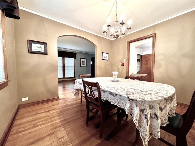 9214 S Sacramento Ave, Evergreen Park, IL 60805 - dining space featuring arched walkways, wood finished floors, a chandelier, crown molding, and baseboards