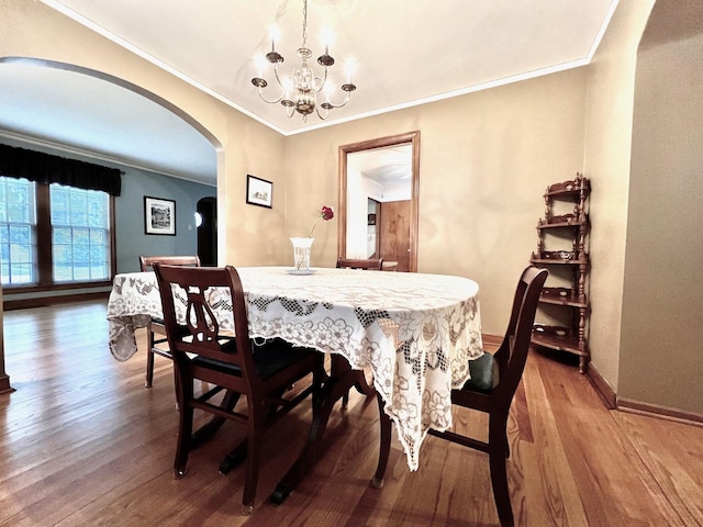 9214 S Sacramento Ave, Evergreen Park, IL 60805 - dining room featuring arched walkways, a chandelier, wood finished floors, crown molding, and baseboards
