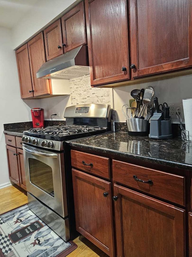 441 Commanche Trl, Wheeling, IL 60090 - kitchen featuring gas range, under cabinet range hood, light wood-style floors, and dark stone countertops