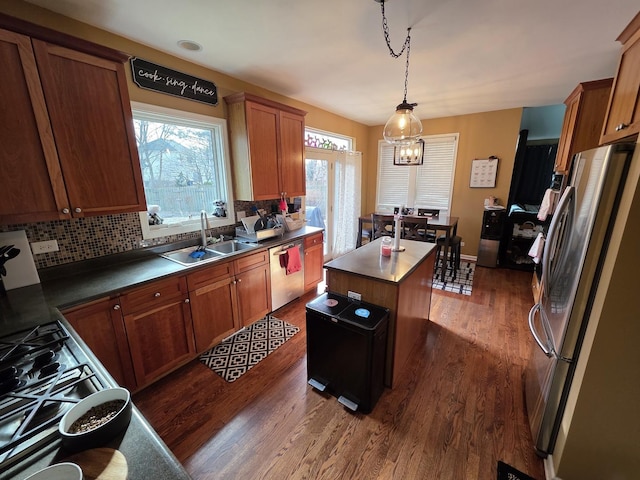 3331 Banford Cir, Lake In The Hills, IL 60156 - kitchen with appliances with stainless steel finishes, a sink, dark wood-style floors, a kitchen island, and tasteful backsplash