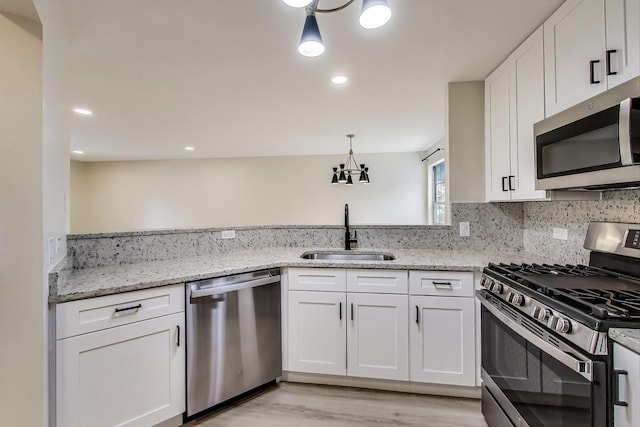 215 W Jennifer Ln Unit 1, Palatine, IL 60067 - kitchen featuring stainless steel appliances, a sink, white cabinetry, light wood-type flooring, and light stone counters