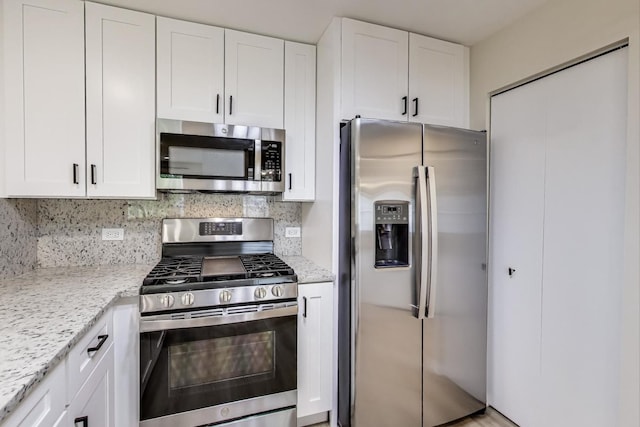 215 W Jennifer Ln Unit 1, Palatine, IL 60067 - kitchen featuring stainless steel appliances, white cabinetry, decorative backsplash, and light stone counters