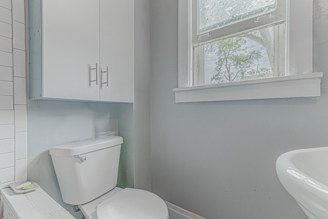 552 Walnut Ave, Elgin, IL 60123 - half bathroom with toilet, baseboards, and a sink
