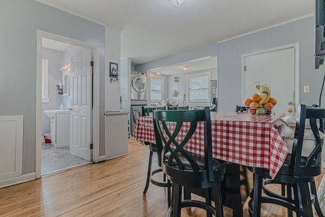 552 Walnut Ave, Elgin, IL 60123 - dining room featuring estacked washer and dryer and light wood-style floors