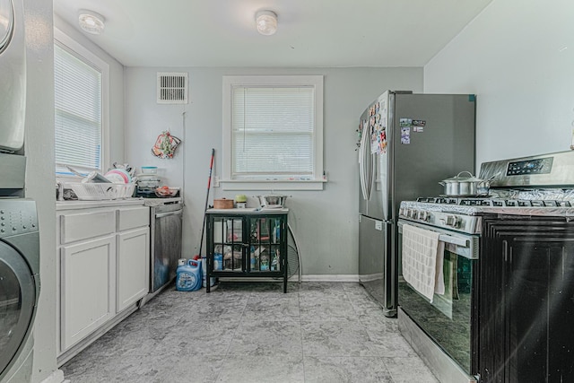 552 Walnut Ave, Elgin, IL 60123 - kitchen featuring stainless steel appliances, washer / clothes dryer, white cabinetry, baseboards, and light countertops