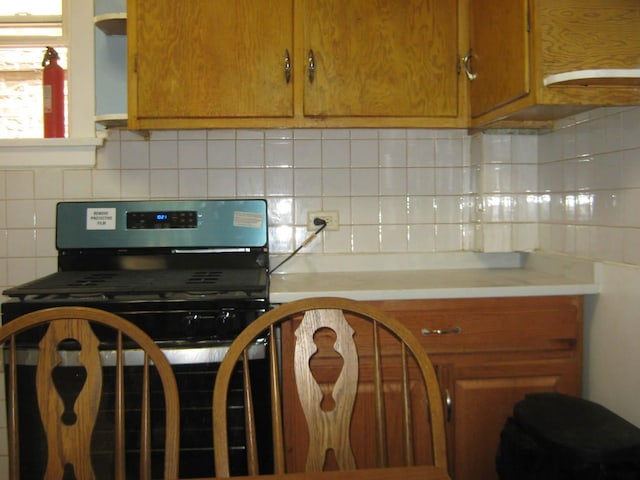 2339 N Kilbourn Ave, Chicago, IL 60639 - kitchen with stainless steel range with gas cooktop, decorative backsplash, and light countertops