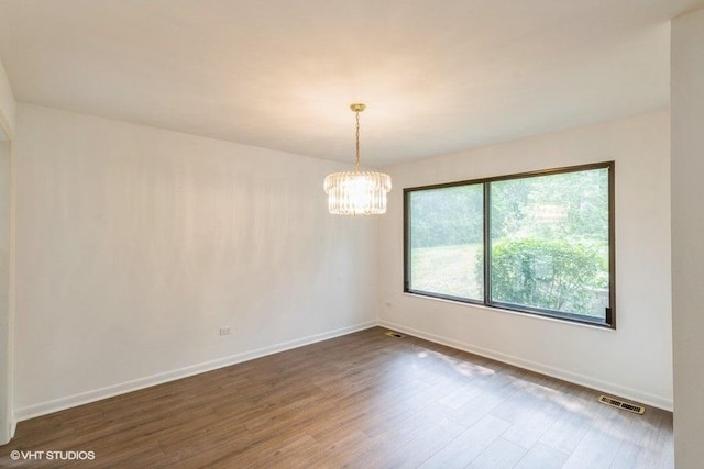 729 Old Barn Rd Unit C, Lake Barrington, IL 60010 - spare room with dark wood-style floors and a chandelier