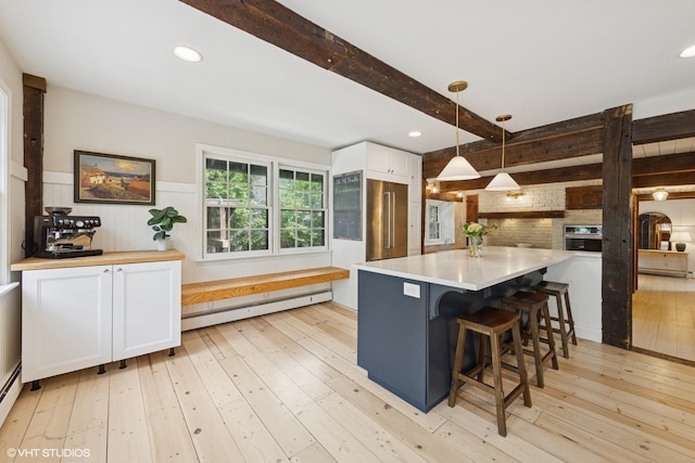 3622 Fairview Ave, Downers Grove, IL 60515 - kitchen featuring a baseboard radiator, white cabinets, light wood-style floors, beamed ceiling, and light countertops