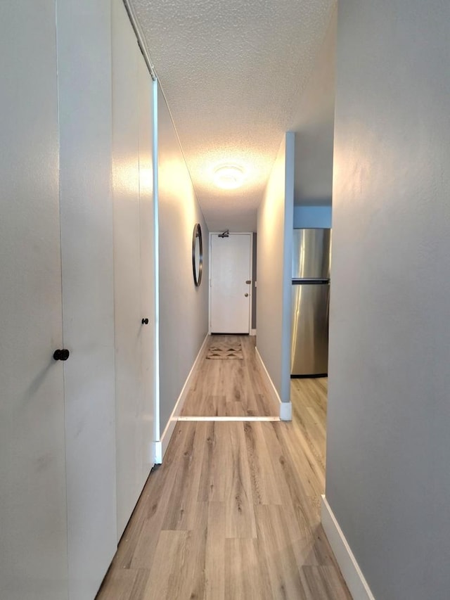 6700 S S Shore Dr Unit 18K, Chicago, IL 60649 - hallway with a textured ceiling, light wood-style floors, and baseboards