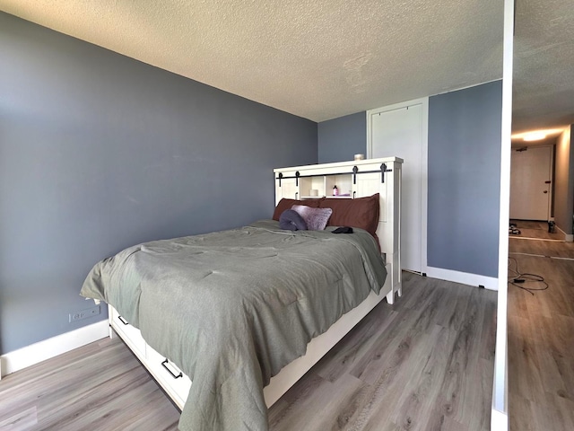 6700 S S Shore Dr Unit 18K, Chicago, IL 60649 - bedroom featuring wood finished floors, a textured ceiling, and baseboards