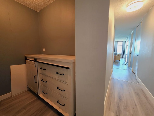 6700 S S Shore Dr Unit 18K, Chicago, IL 60649 - hallway with a textured ceiling, light wood-type flooring, and baseboards