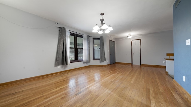 10129 Asbury Ln, Machesney Park, IL 61115 - unfurnished room with a chandelier, light wood-style flooring, and baseboards