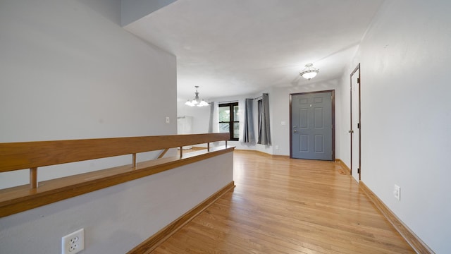 10129 Asbury Ln, Machesney Park, IL 61115 - hall with a chandelier, light wood finished floors, and baseboards