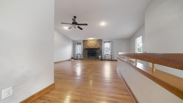 10129 Asbury Ln, Machesney Park, IL 61115 - unfurnished living room featuring ceiling fan, baseboards, a fireplace, light wood finished floors, and vaulted ceiling