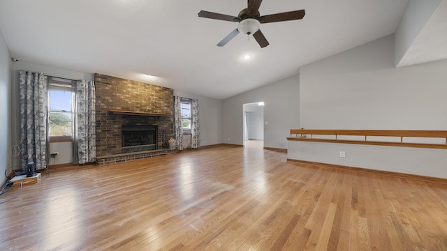 10129 Asbury Ln, Machesney Park, IL 61115 - unfurnished living room featuring lofted ceiling, light wood-type flooring, a brick fireplace, a ceiling fan, and baseboards