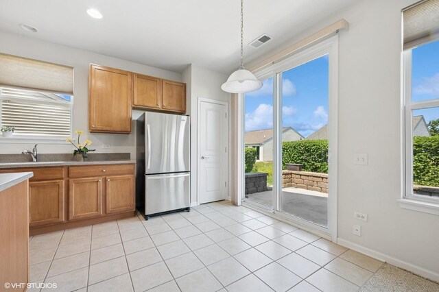 3332 Sheridan Ln, Mundelein, IL 60060 - kitchen with freestanding refrigerator, decorative light fixtures, light tile patterned floors, and brown cabinetry