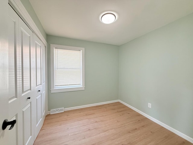 1327 N Pleasant Dr, Round Lake Beach, IL 60073 - unfurnished bedroom featuring a closet, light wood-type flooring, and baseboards