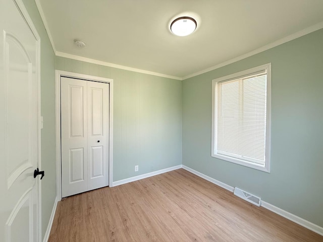 1327 N Pleasant Dr, Round Lake Beach, IL 60073 - unfurnished bedroom featuring crown molding, light wood-style floors, baseboards, and a closet