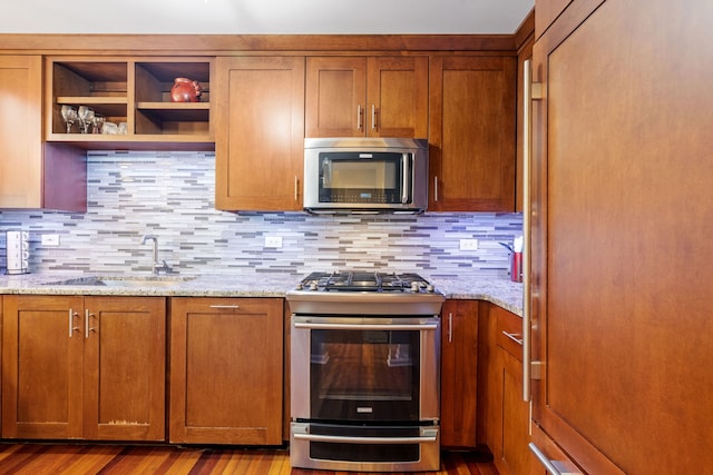 3502 Lake Side Cir, Joliet, IL 60431 - kitchen featuring appliances with stainless steel finishes, a sink, open shelves, brown cabinets, and tasteful backsplash