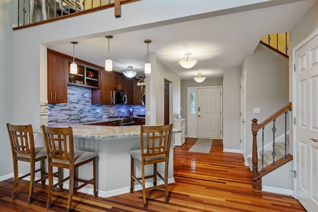 3502 Lake Side Cir, Joliet, IL 60431 - kitchen featuring stainless steel appliances, light wood-style flooring, backsplash, and a breakfast bar area