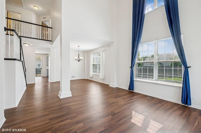 955 S Roxbury Ct, Round Lake, IL 60073 - unfurnished living room with a towering ceiling, wood finished floors, and a chandelier