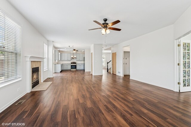 955 S Roxbury Ct, Round Lake, IL 60073 - unfurnished living room featuring ceiling fan, dark wood finished floors, a fireplace, and stairs