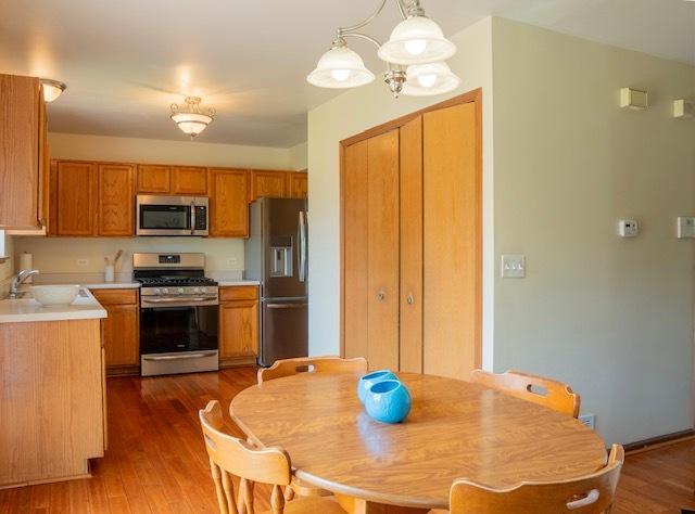 1413 N Metropolitan Ave, Waukegan, IL 60085 - kitchen with appliances with stainless steel finishes, a sink, light countertops, and wood finished floors