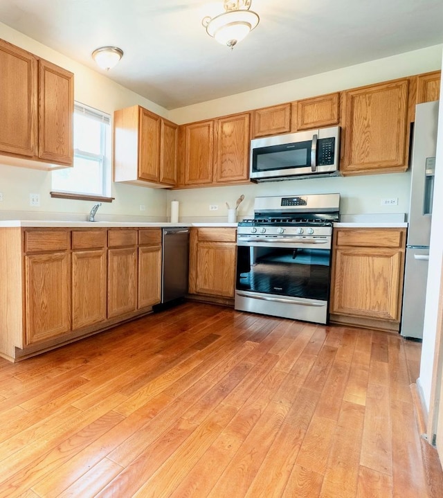 1413 N Metropolitan Ave, Waukegan, IL 60085 - kitchen with stainless steel appliances, light wood-style floors, and light countertops
