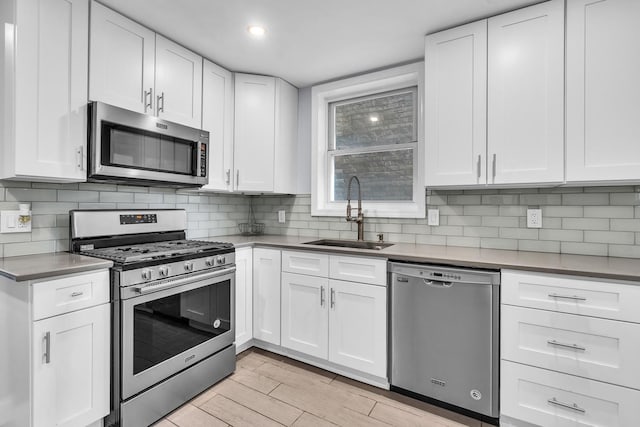 6210 N Francisco Ave, Chicago, IL 60659 - kitchen featuring stainless steel appliances, a sink, light wood-type flooring, white cabinetry, and recessed lighting