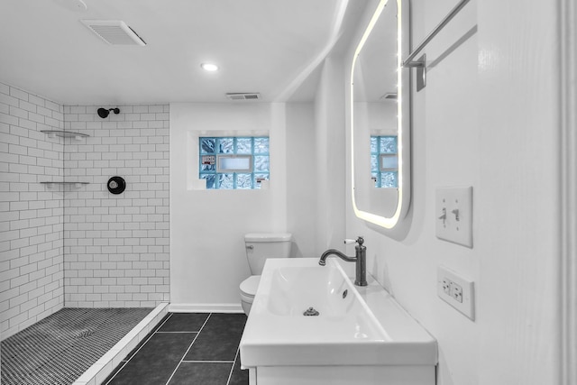 6210 N Francisco Ave, Chicago, IL 60659 - bathroom with a tile shower, toilet, vanity, tile patterned floors, and recessed lighting