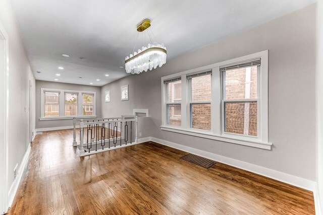 5544 S California Ave, Chicago, IL 60629 - empty room with wood finished floors, baseboards, a chandelier, and recessed lighting