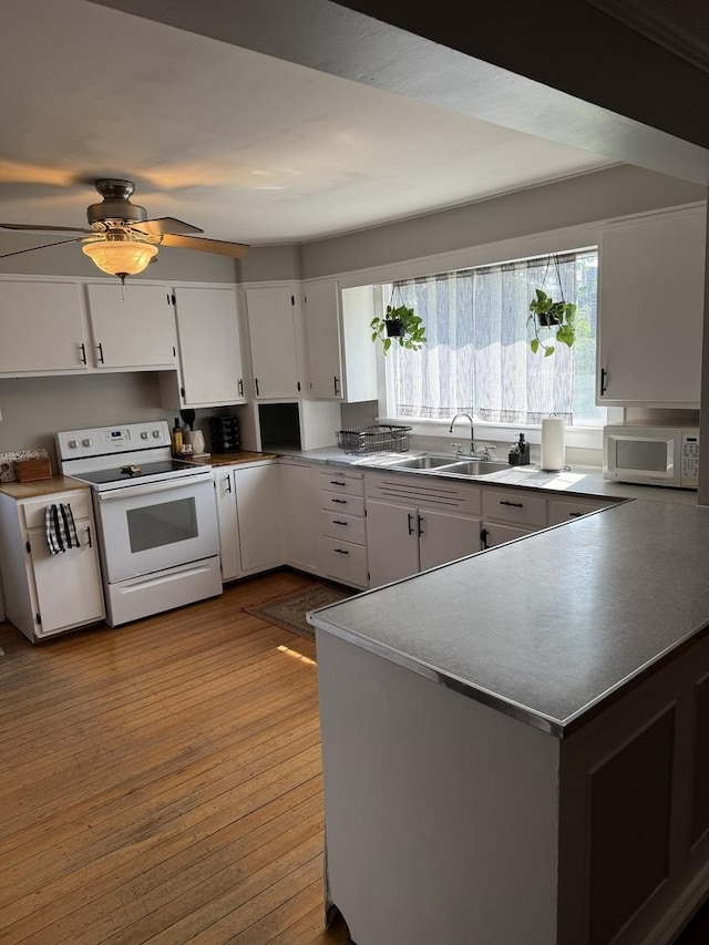 26 Elm Pl, Princeton, IL 61356 - kitchen featuring white appliances, a sink, washer / clothes dryer, white cabinetry, and dark wood-style floors
